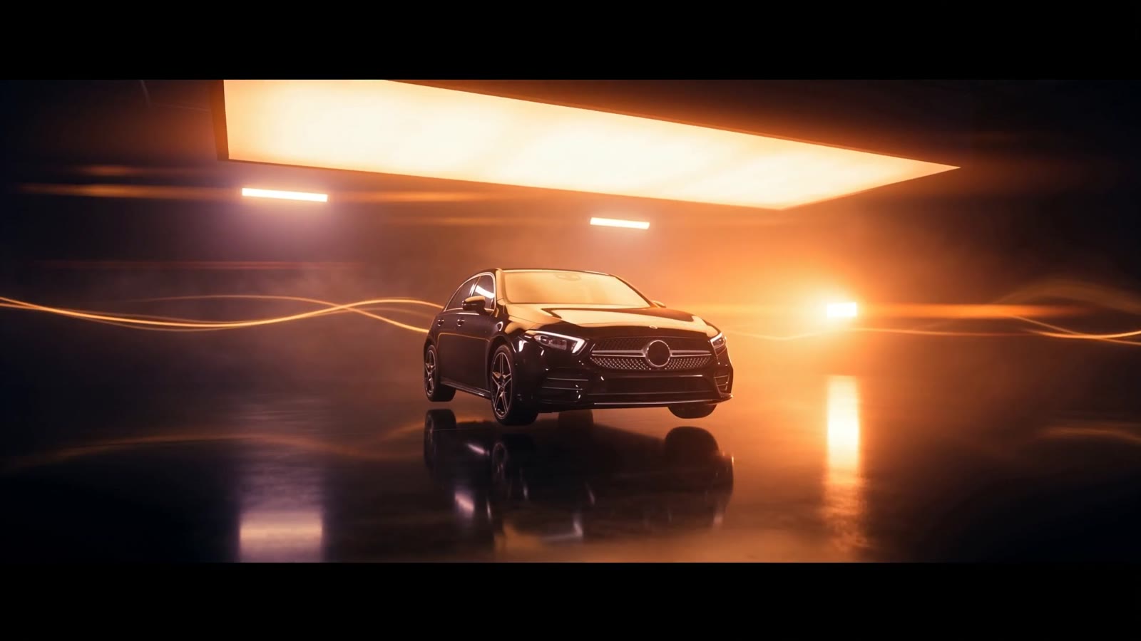 A black saloon car in a dark studio with streaks of orange light